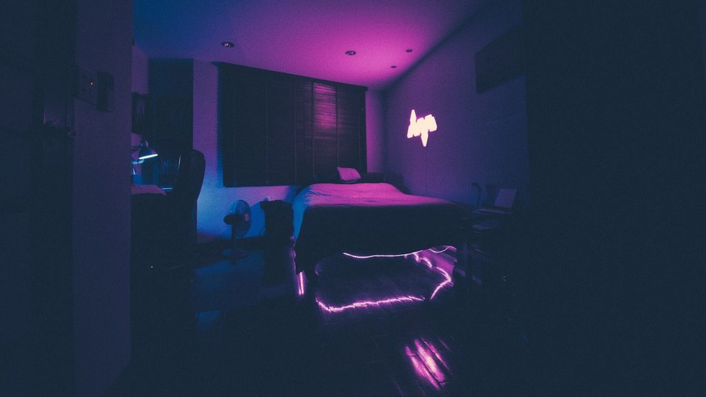 Una habitación con luces RGB debajo de la cama